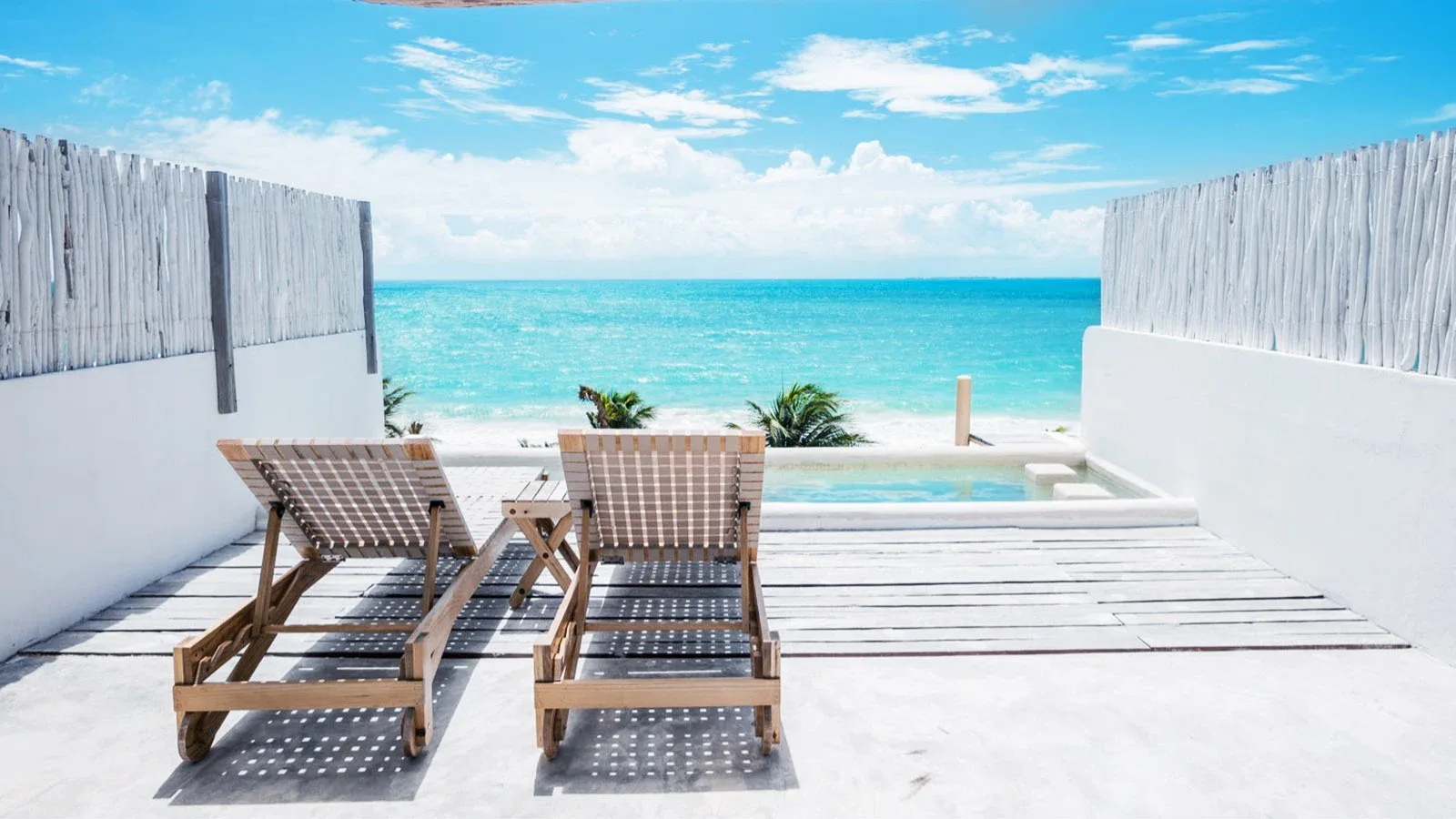 Dos camastros en una terraza privada de Punta Blanca, frente a la alberca y el mar turquesa del Caribe