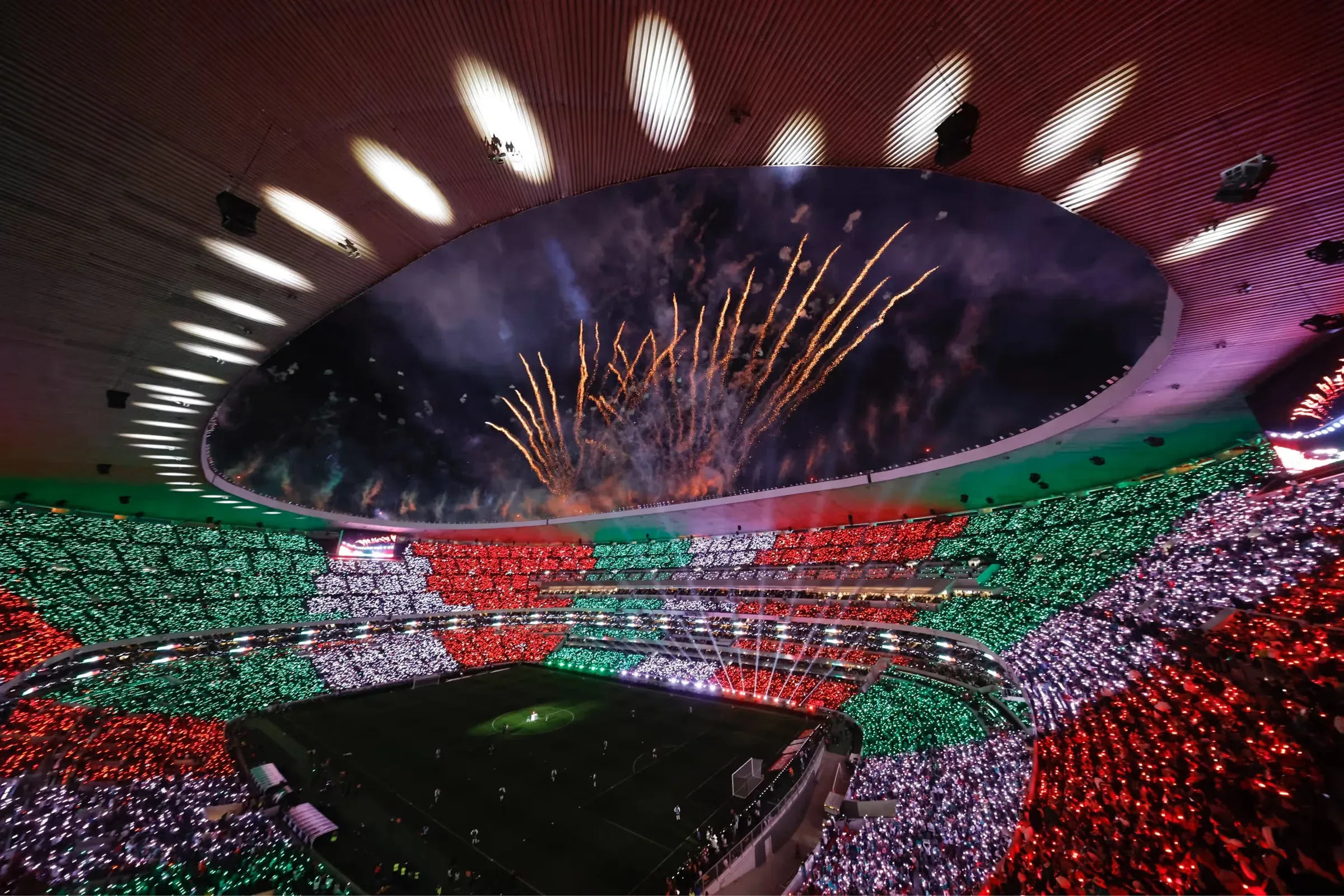 El Estadio Ciudad de México de noche, con fuegos artificiales sobre la cancha y las gradas en verde, blanco y rojo